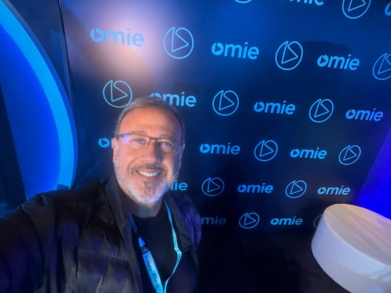 Participante diante de um painel com a marca Omie no Conecta Day